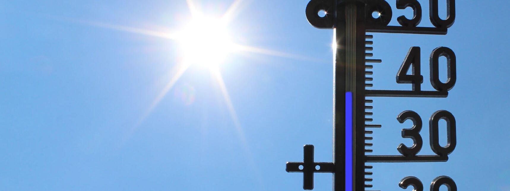 Thermometer vor blauem Himmel, zeigt 40 Grad
