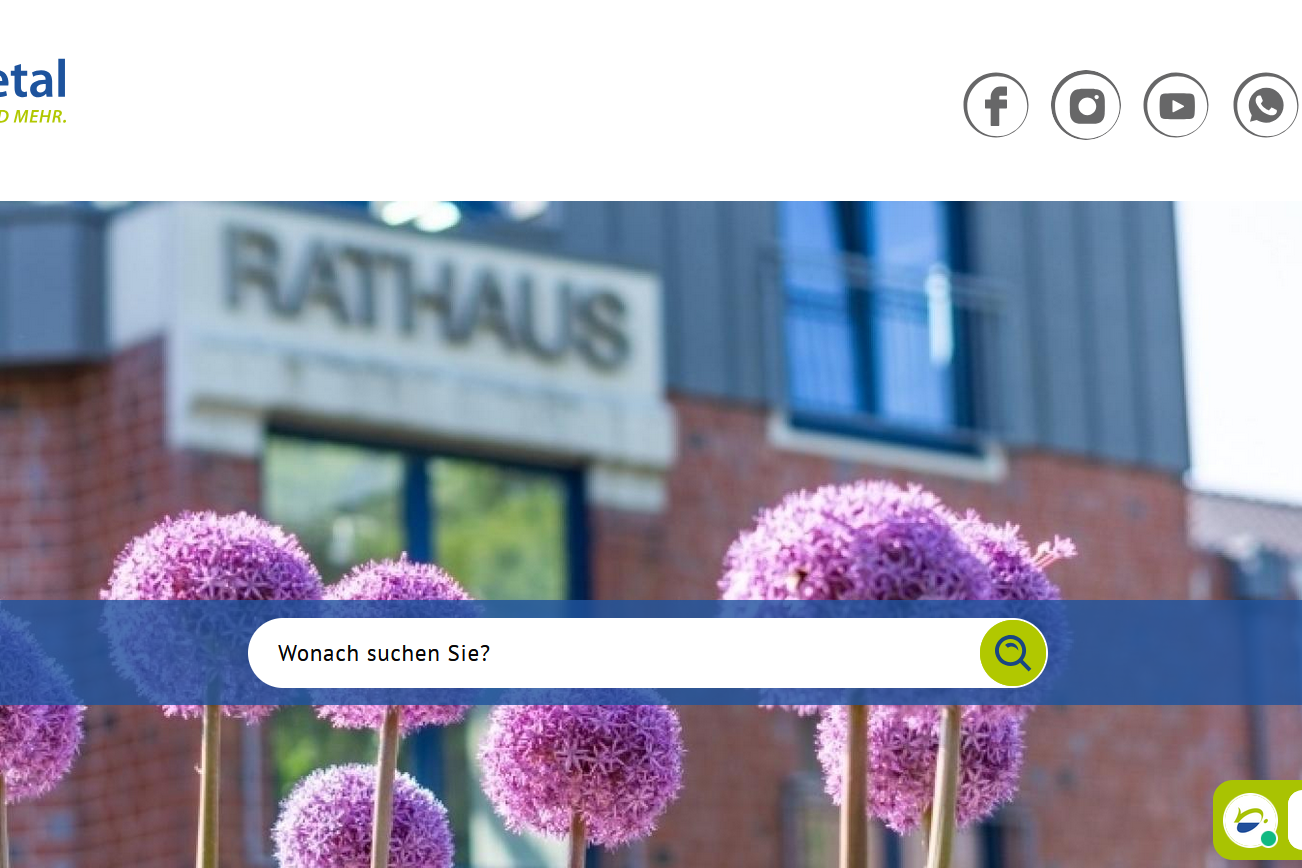 Die Homepage der Stadt Nettetal, im Vordergrund schöne Blumen, im Hintergrund - etwas verschwommen - das Rathaus.