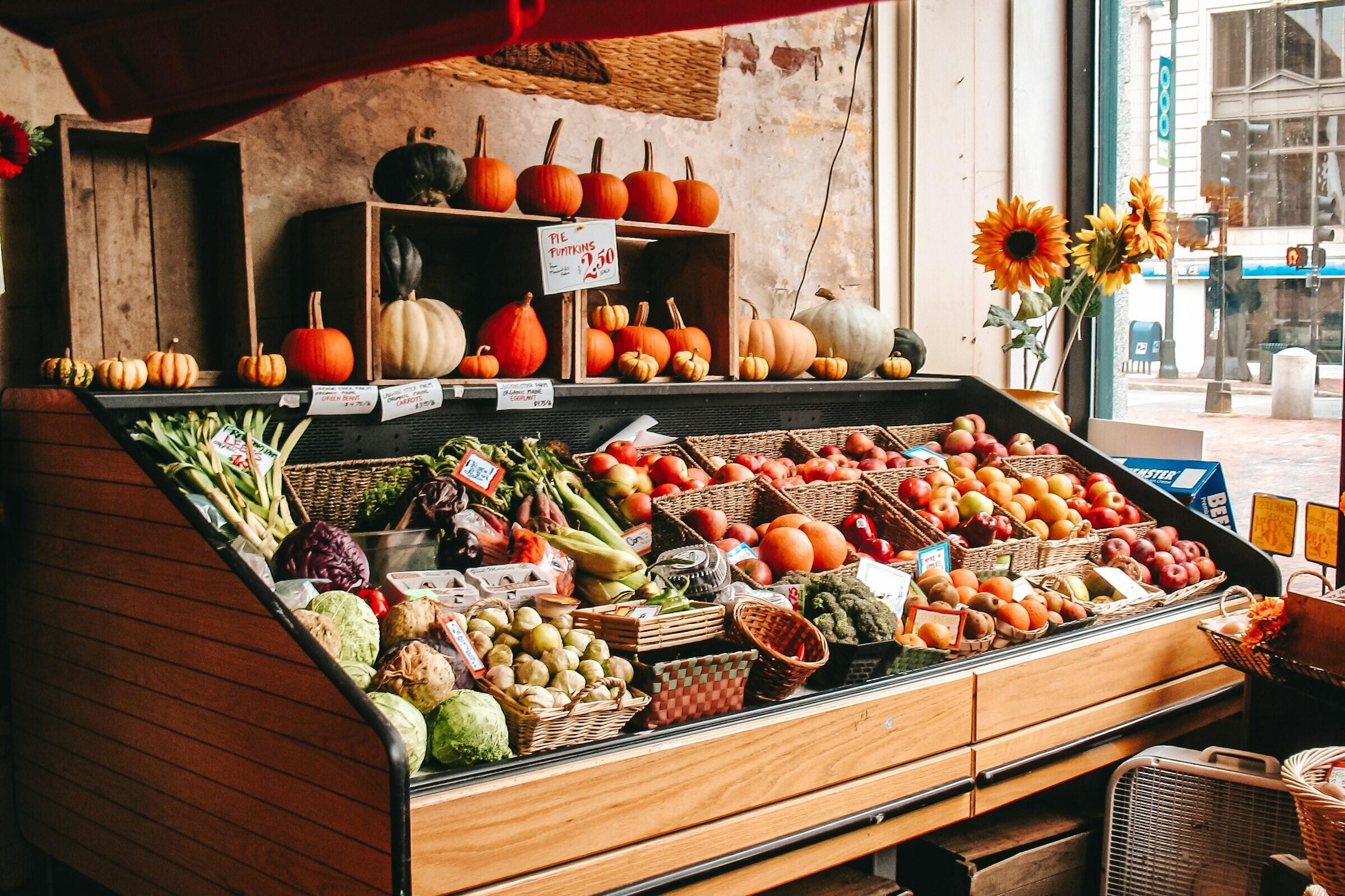 Eine wunderbare Obst- und Gemüstheke mit viel Holz und schönen Herbstfrüchten