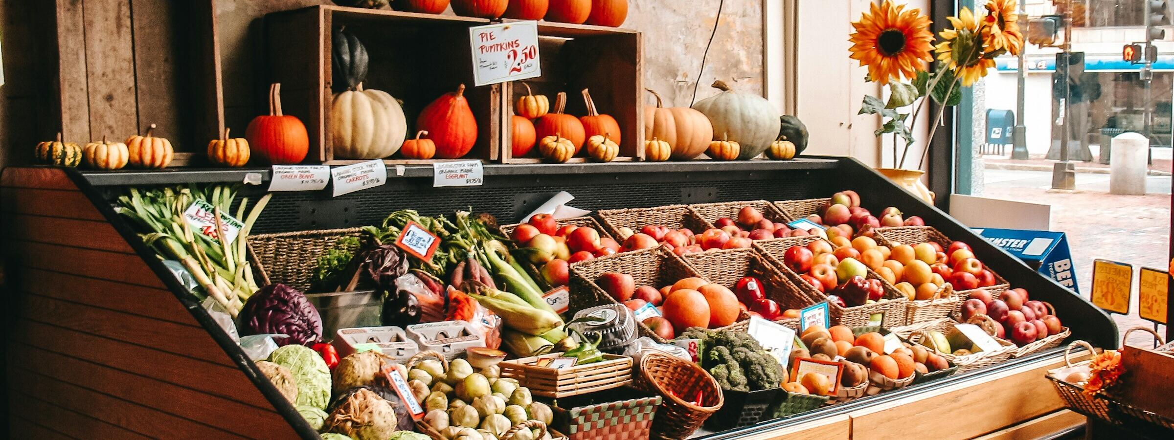 Eine wunderbare Obst- und Gemüstheke mit viel Holz und schönen Herbstfrüchten