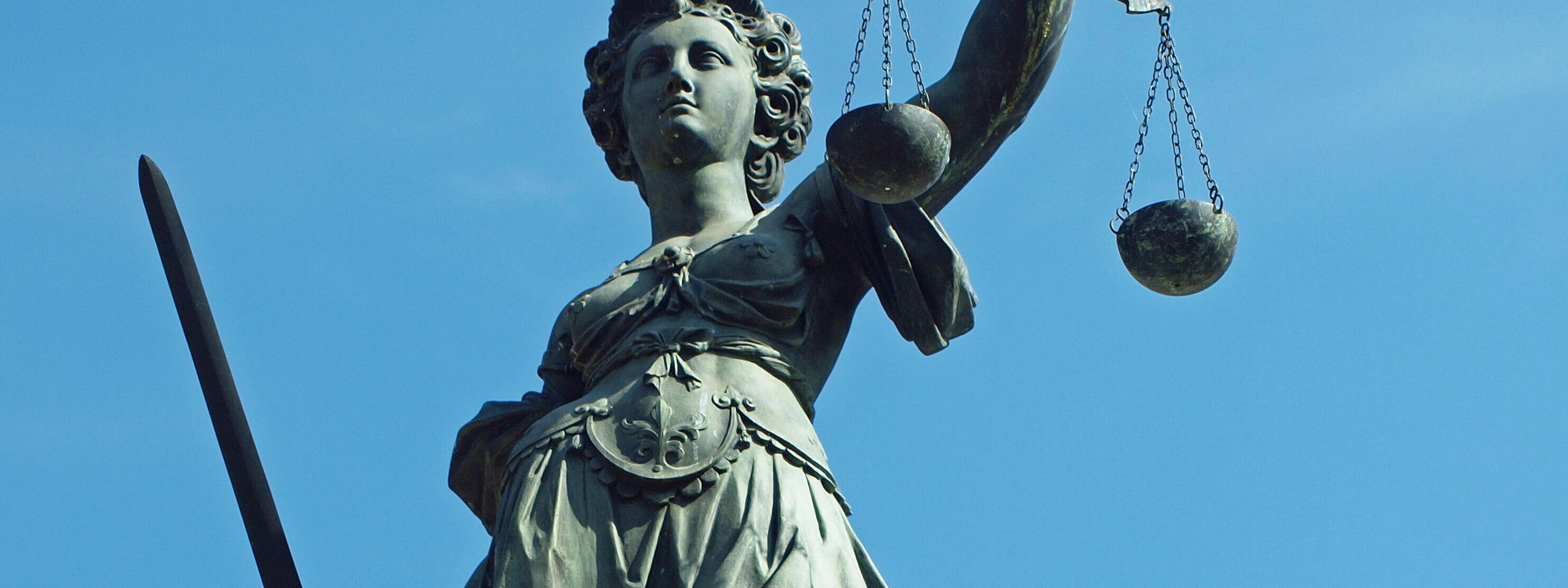 Justitia mit blauem Himmel im Hintergrund