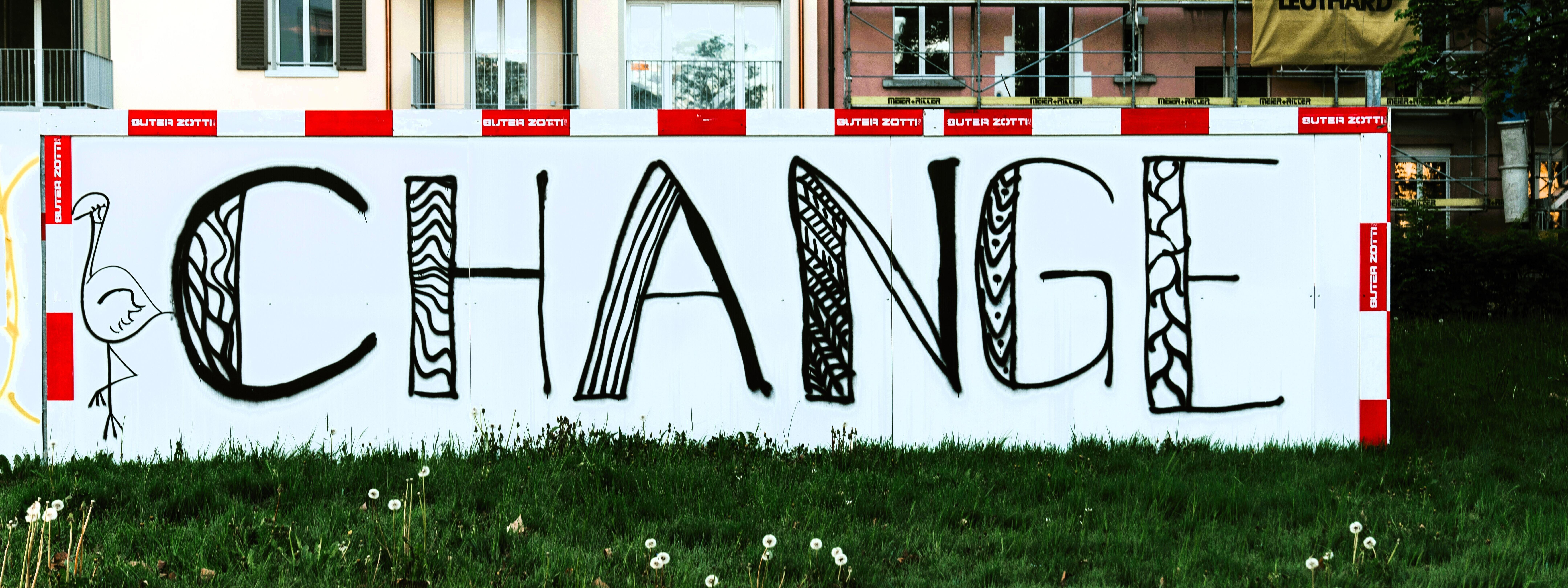 Eine typisch städtische Häuserzeile mit Baugerüst und dem Banner "Change" davor