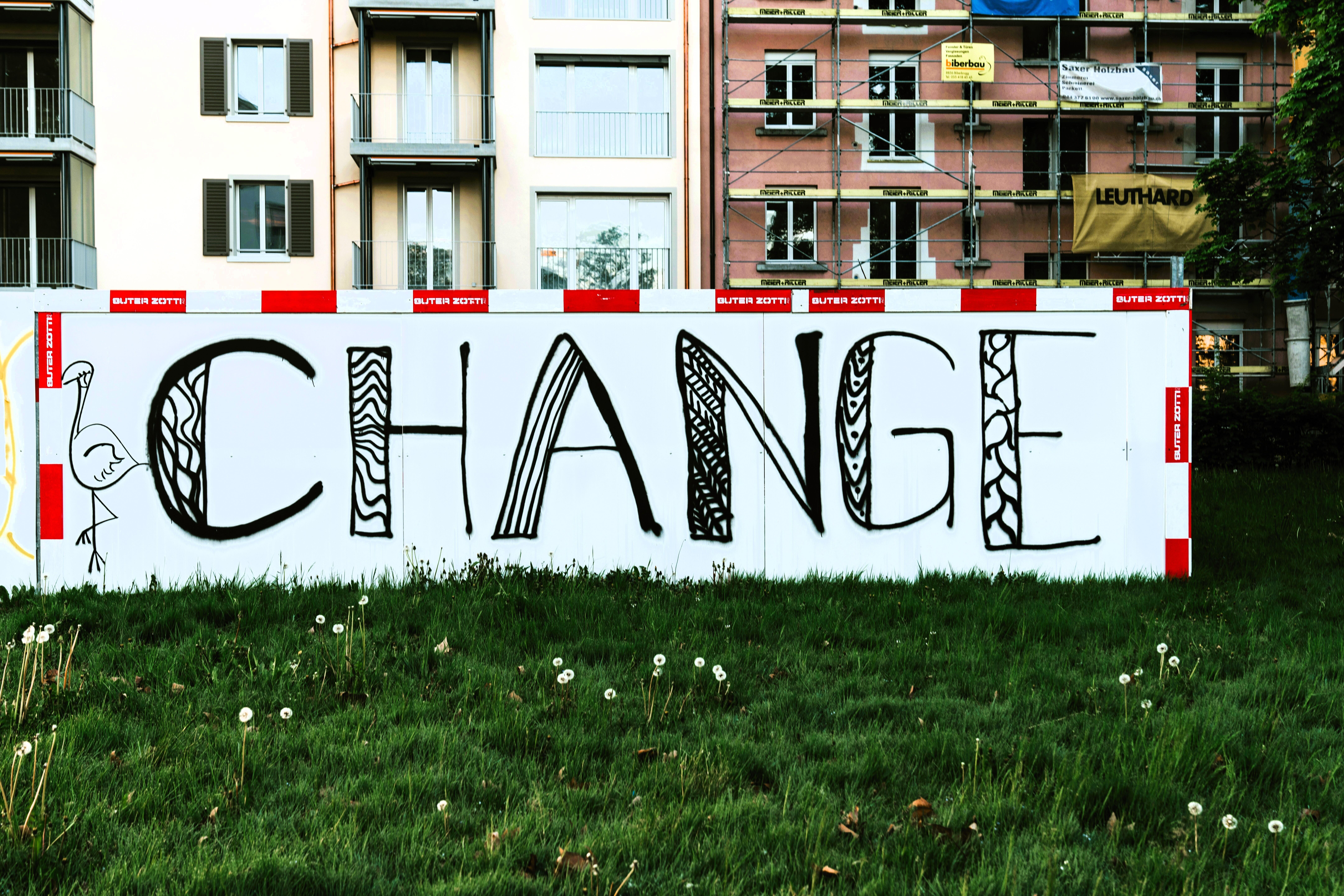 Eine typisch städtische Häuserzeile mit Baugerüst und dem Banner "Change" davor
