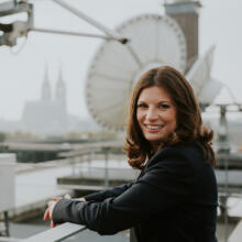 Portrait Anna-Katharina Schubert auf einem Dach vor einer Satelitenschüssel.